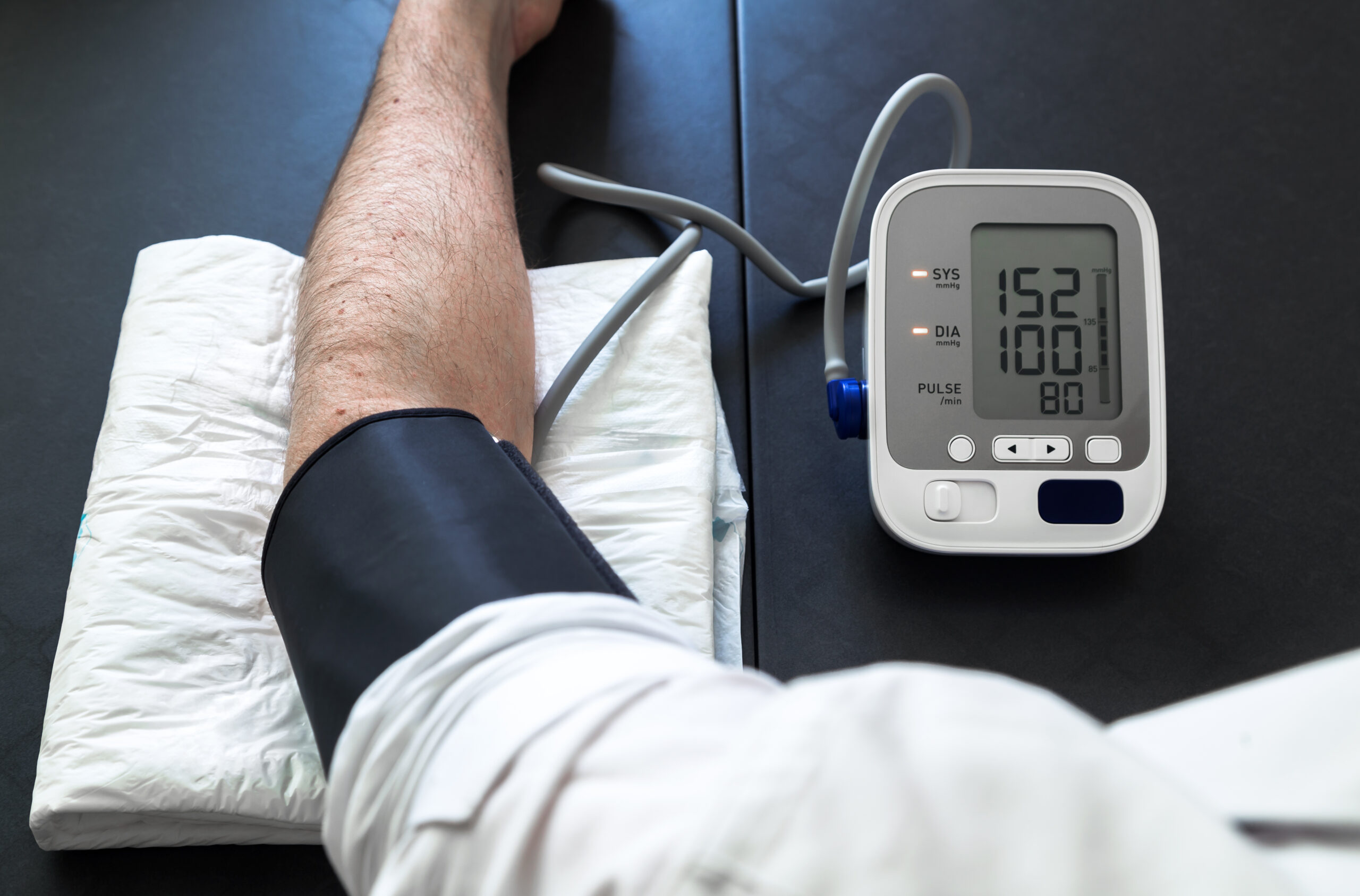Hypertensive patient performing a blood pressure auto test / man self-monitoring of blood pressure with a tensiometer